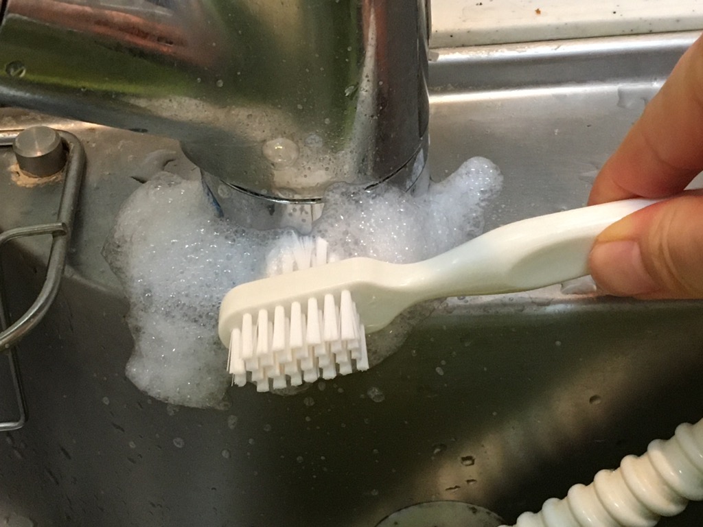 入れ歯用ブラシでシンクを磨く