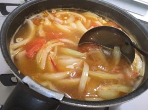 赤いスープに味噌を溶かす