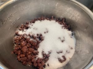 煮た小豆に砂糖を混ぜる